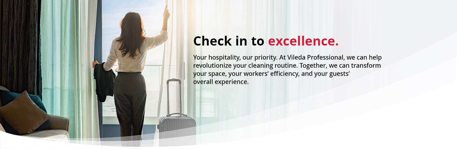 A hotel guest stands in a brightly lit room with their back to the camera, opening white sheer curtains to look out a large window. Next to them is a piece of luggage, and to the right, the text reads, "Check in to excellence. Your hospitality, our priority. At Vileda Professional, we can help revolutionize your cleaning routine. Together, we can transform your space, your workers’ efficiency, and your guests’ overall experience".